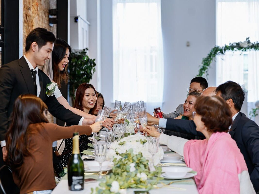 Family toasting glasses at long table at Austin wedding