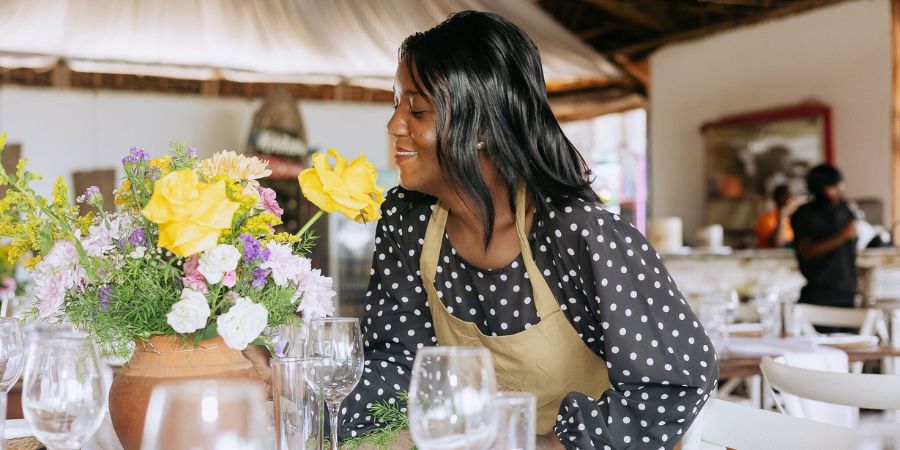 Wedding planner arranging floral table decor, showing expertise in how to plan a destination wedding with style and organization.