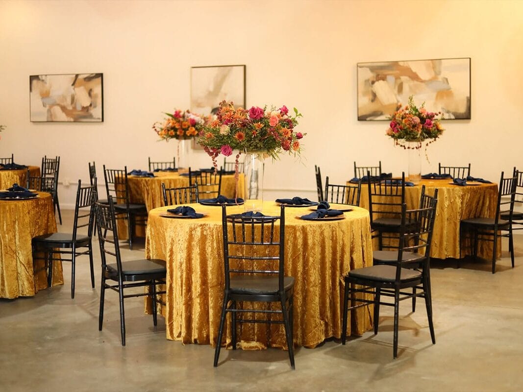 Atlanta wedding planner created space with round gold tables, black chairs, floral centerpieces