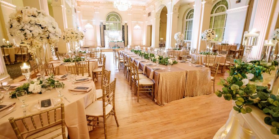 Luxury wedding reception setup with gold chairs and elegant floral décor, an example of how to start an event planning business with high-end events. Planned by Tyler Reid of Eminent Events. Photography by Forever Photography by Daniel Lee.