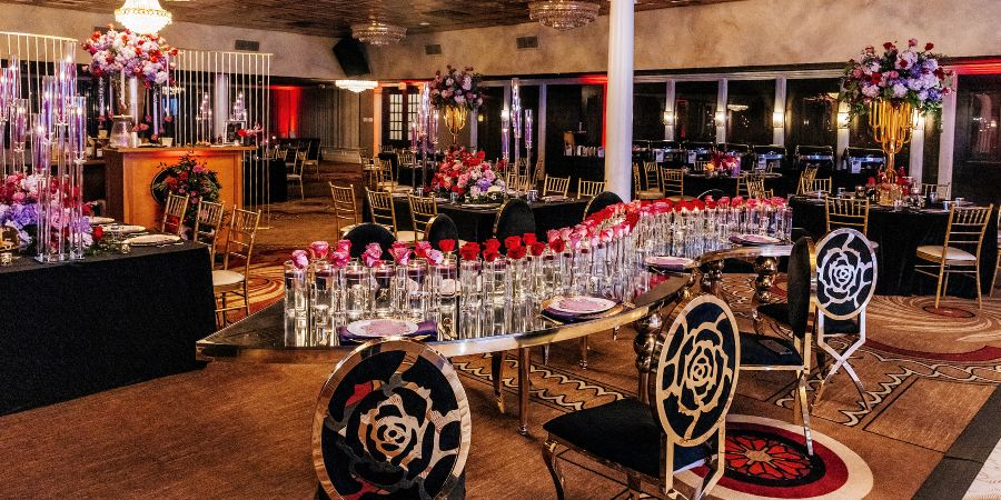 Elegant ballroom with chandeliers, floral centerpieces, and luxury table settings, showcasing ideas for an event planning business plan. Planned by Tyler Reid of Eminent Events. Photography by Forever Photography by Stanlo Photography.