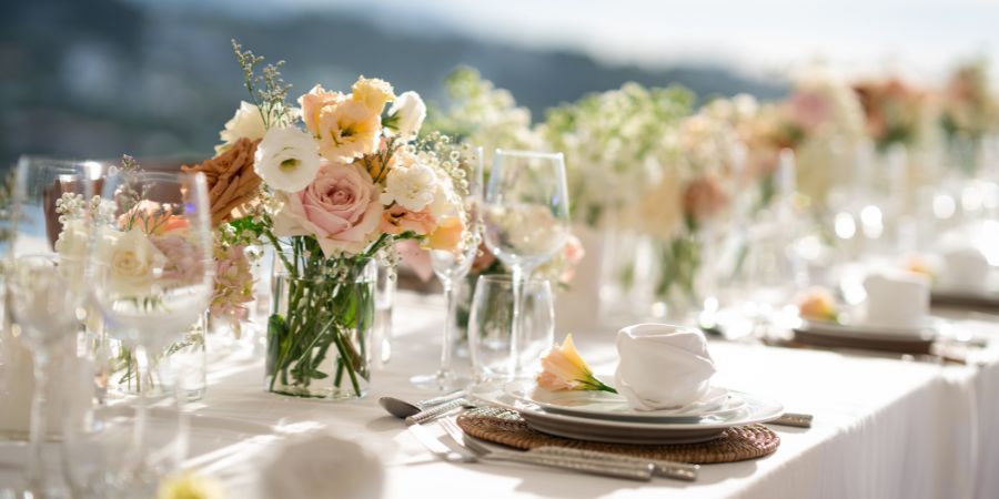 Elegant wedding reception table with floral arrangements and fine dining setup, an example planners use when learning how to start planning a wedding.