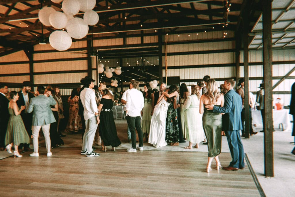 Group of Los Angeles wedding attendees at indoor venue resembling barn