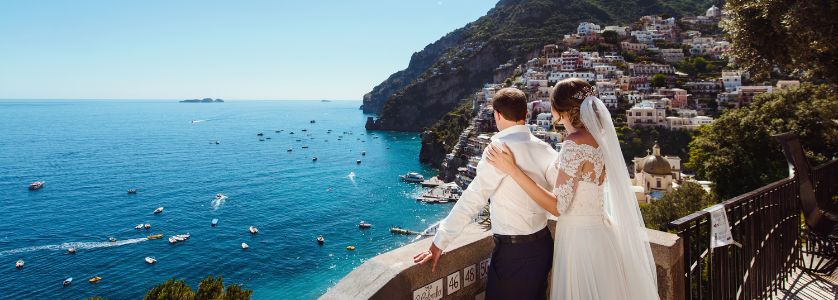 Bride and groom overlooking the Amalfi Coast while researching how to plan a destination wedding, showcasing romantic destination wedding locations abroad.