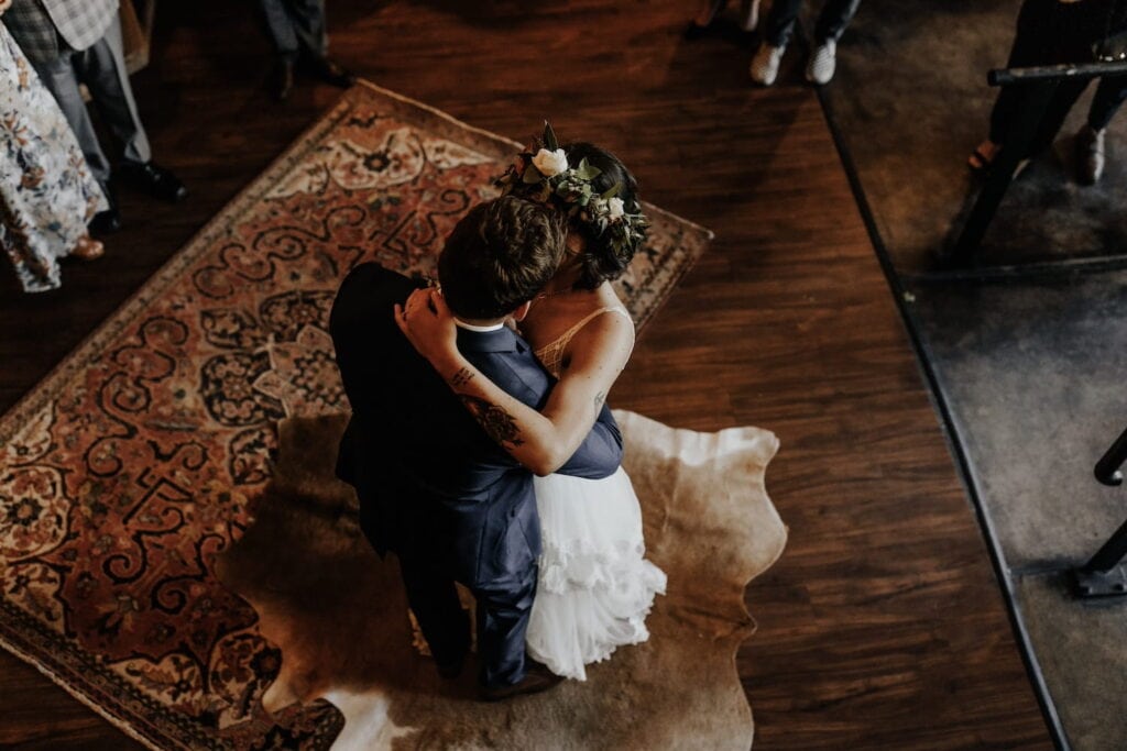 An overhead shot of a bride and groom dancing in a warm, cozy room
