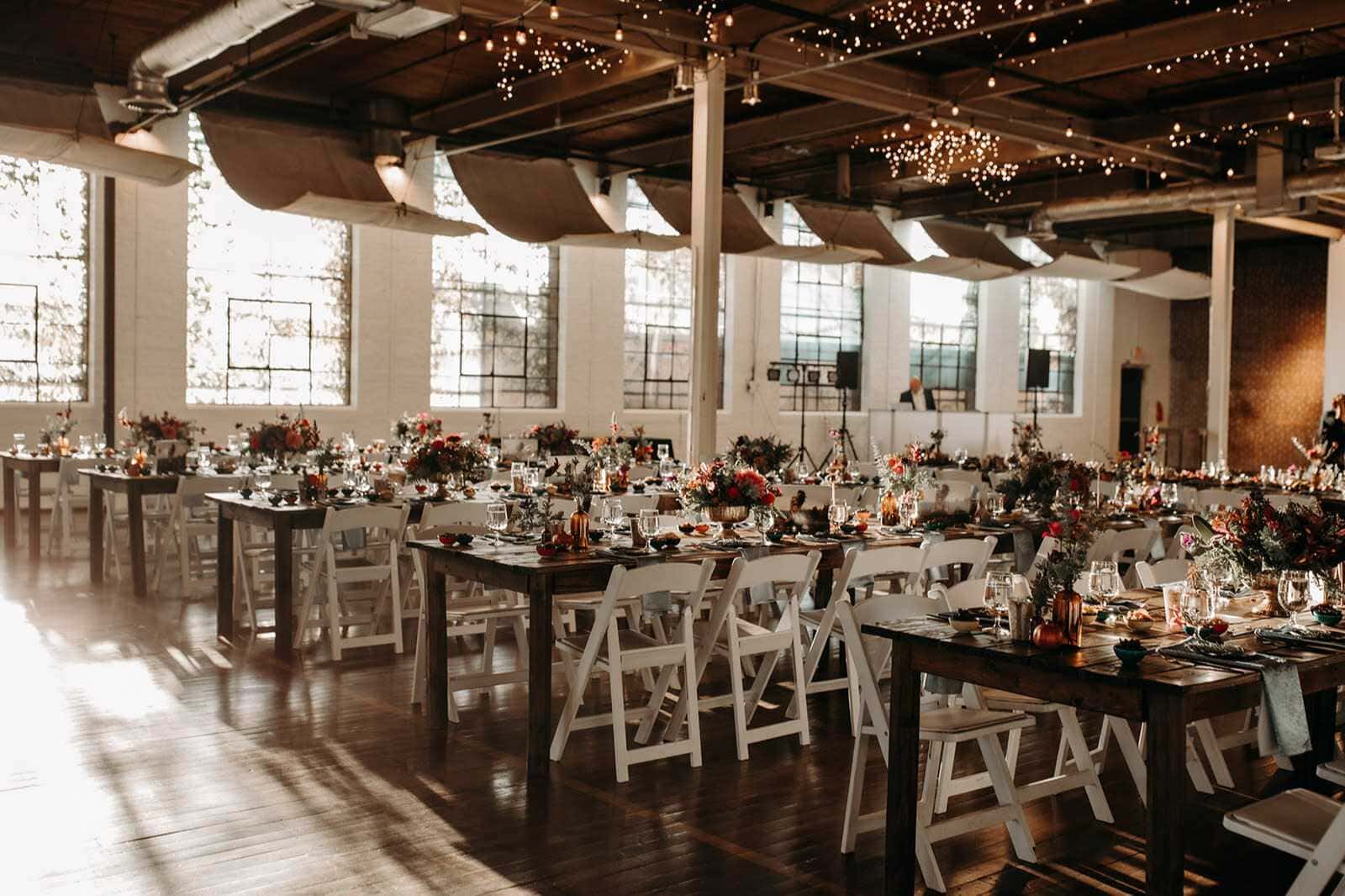 Elegant wedding reception with long tables in a Denver loft space