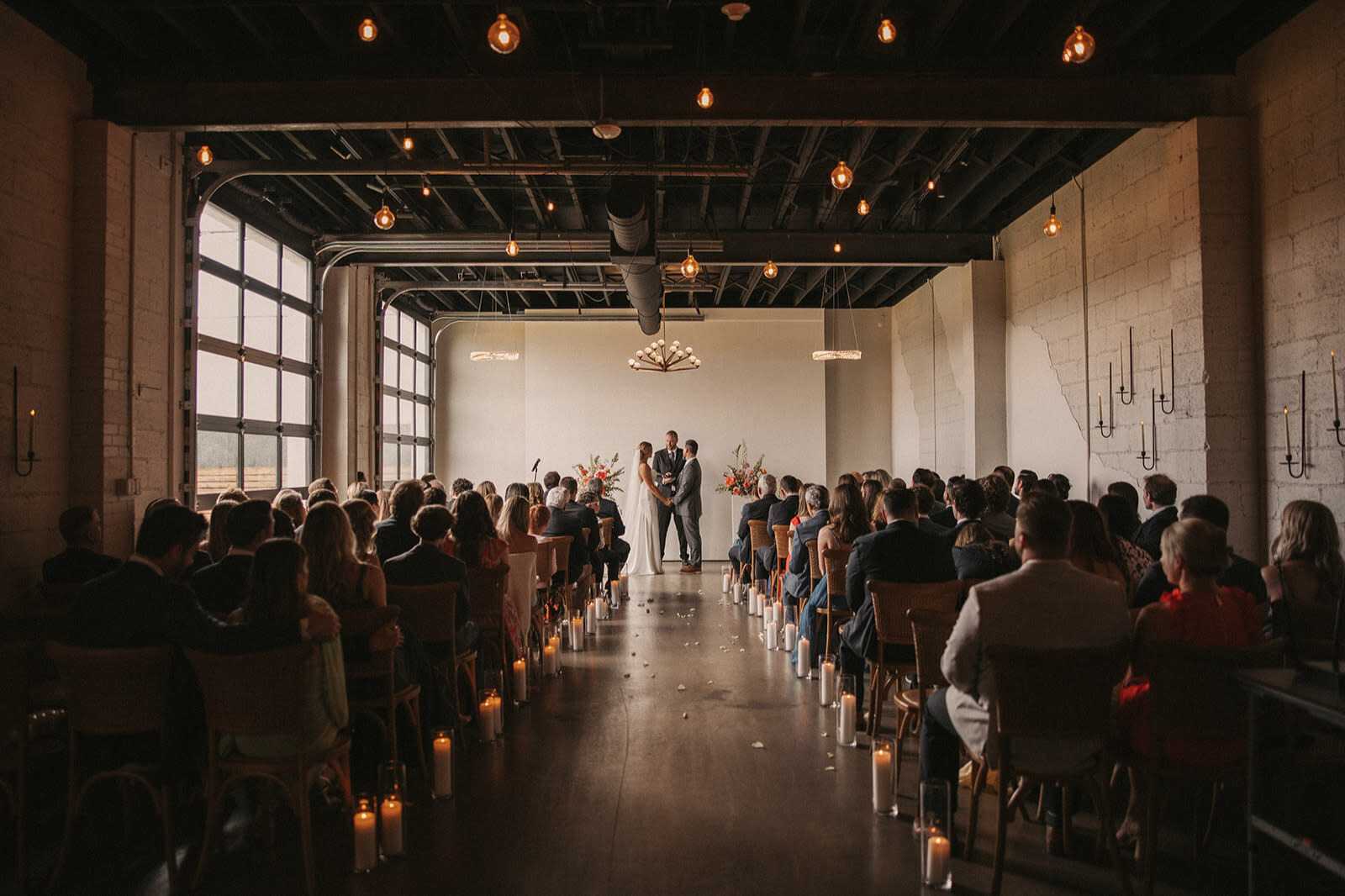 Indoor wedding ceremony at a rustic industrial venue in Denver