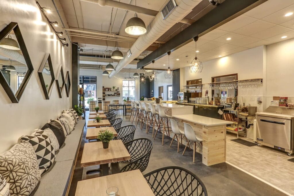 A light, bright wine bar with a bar area and many different seating arrangements