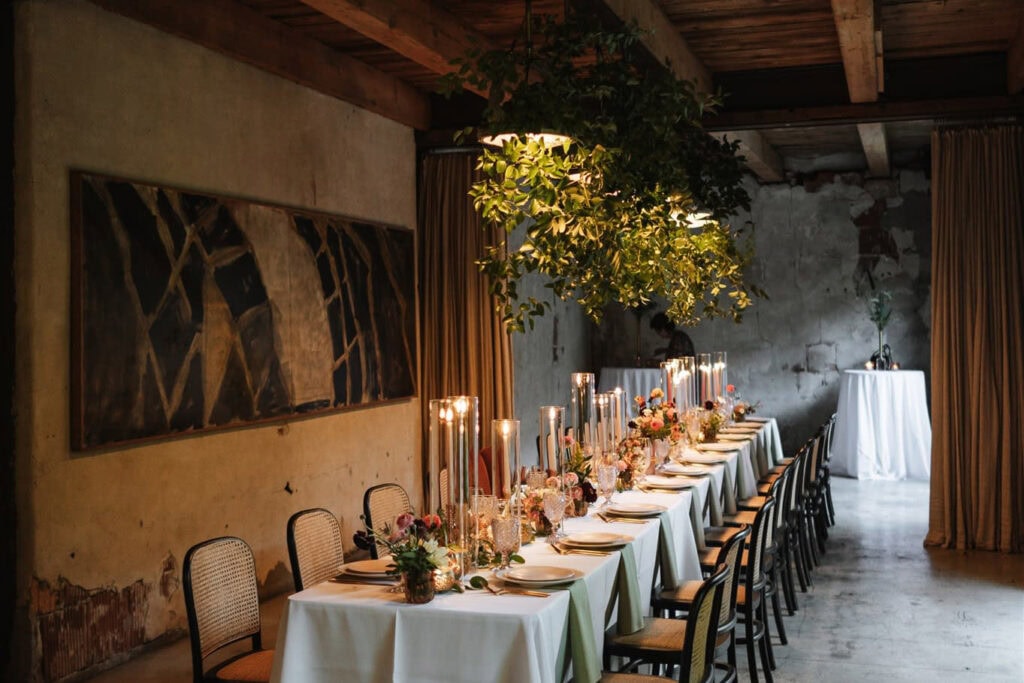 Indoor Utah wedding venue with long table, greenery, and candles