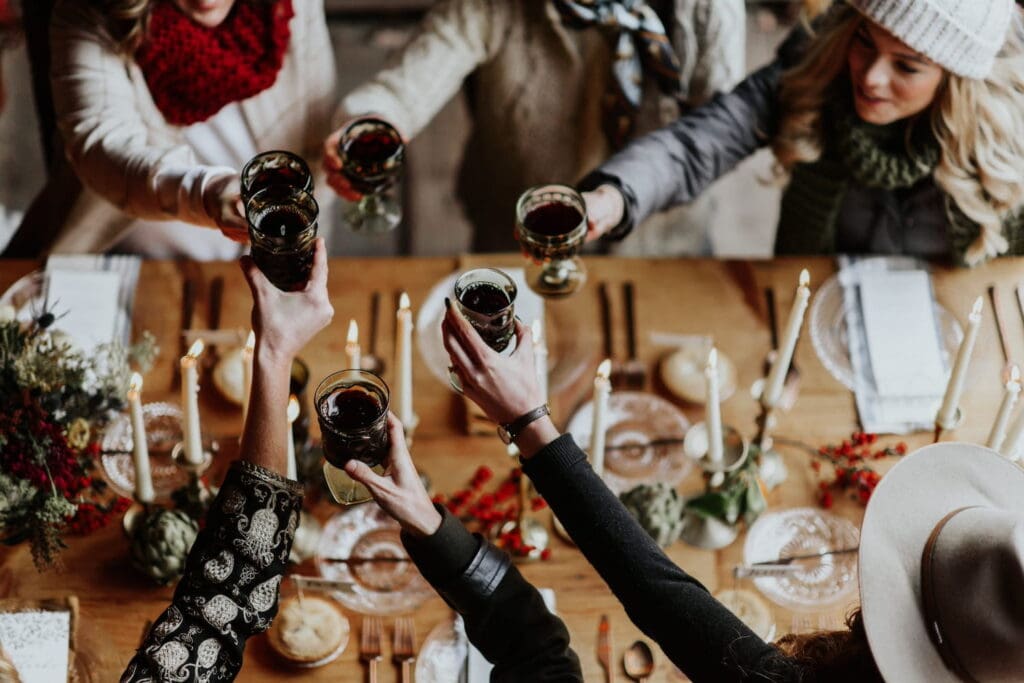 Overhead shot of women toasting with wine over a wooden table