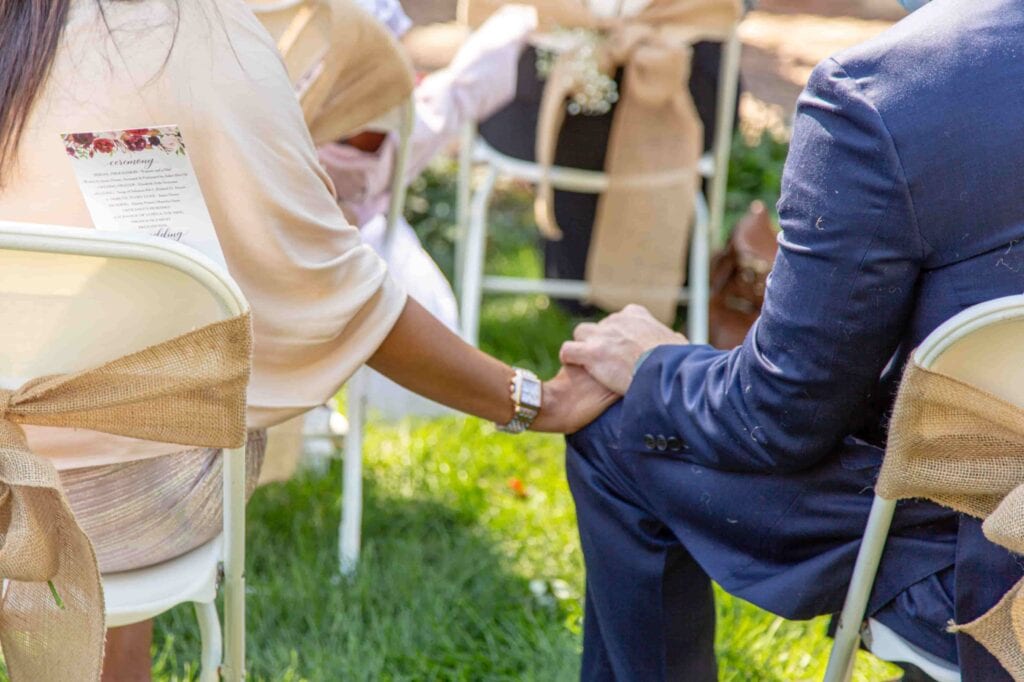 Bride and groom holding hands at garden wedding ceremony in Kansas