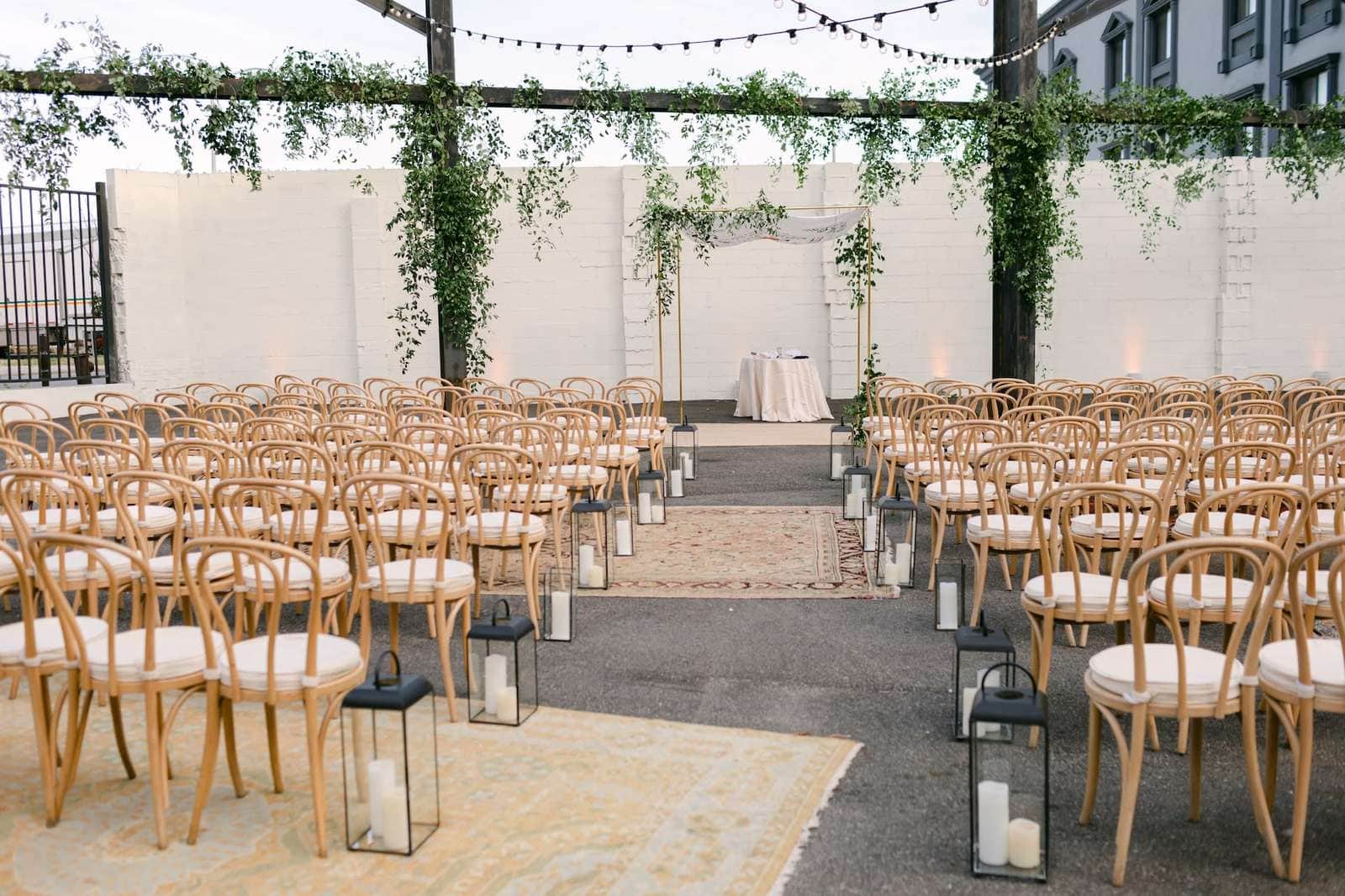 Outdoor Columbus wedding ceremony setup with string lights and wooden chairs