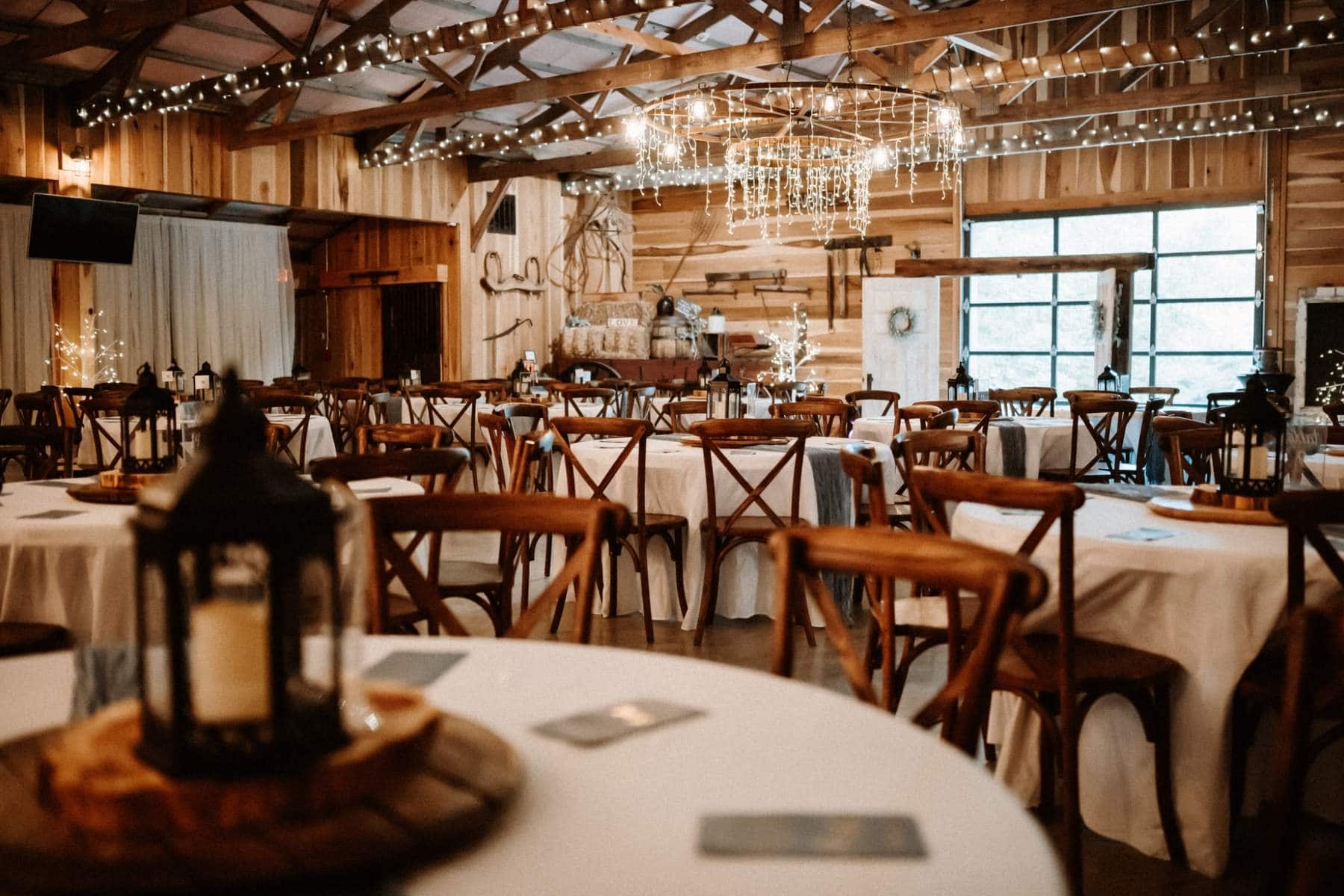 Rustic indoor barn reception venue with string lights in Louisville