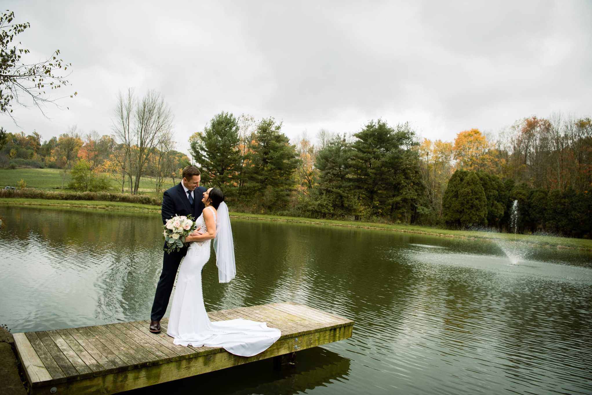Couple standing on a dock by a pond during Connecticut autumn