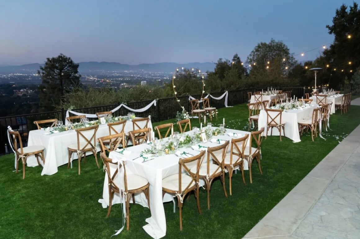 Elegant outdoor California wedding reception setup overlooking city lights and mountains