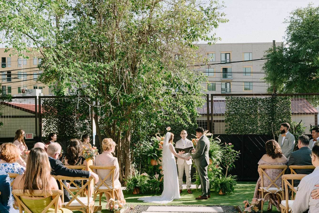 Outdoor Milwaukee wedding ceremony under large tree with seated guests