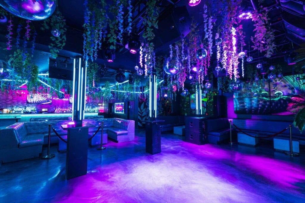 Indoor club space LA p arty venue with neon lights and hanging florals