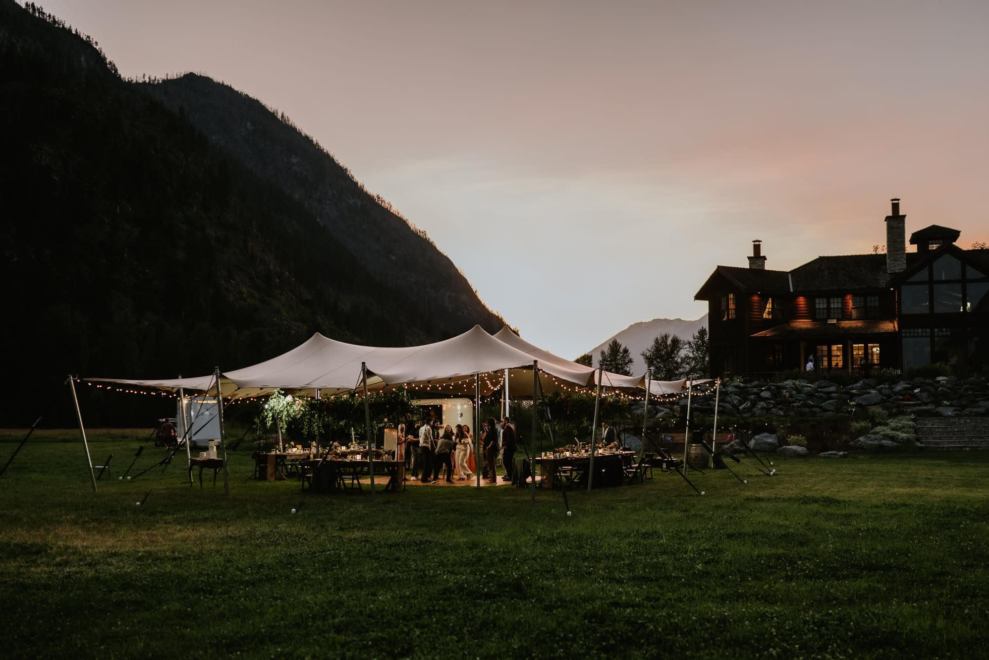 Illuminated outdoor wedding tent reception in a North Carolina mountain valley