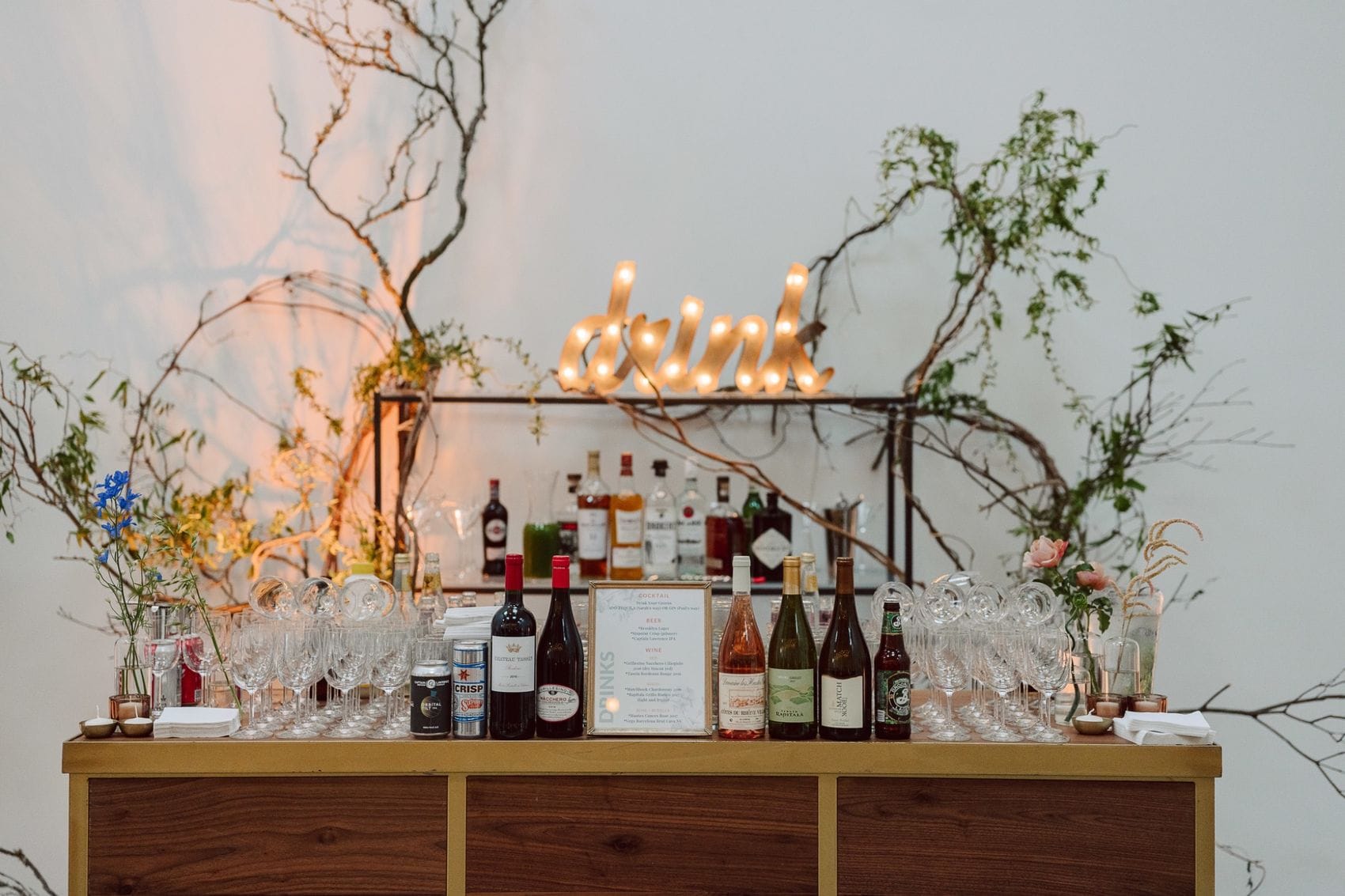 Rustic wedding bar setup with illuminated sign managed by Phoenix planners