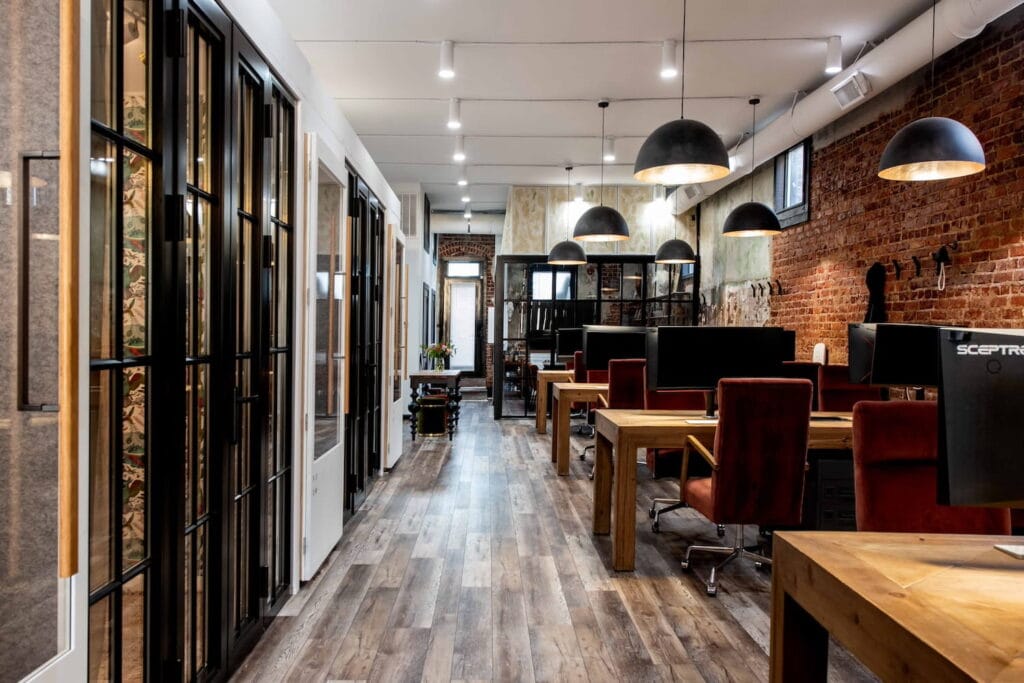 Brick walls, overhead lighting and dark wood furniture warm up an industrial office space in Atlanta