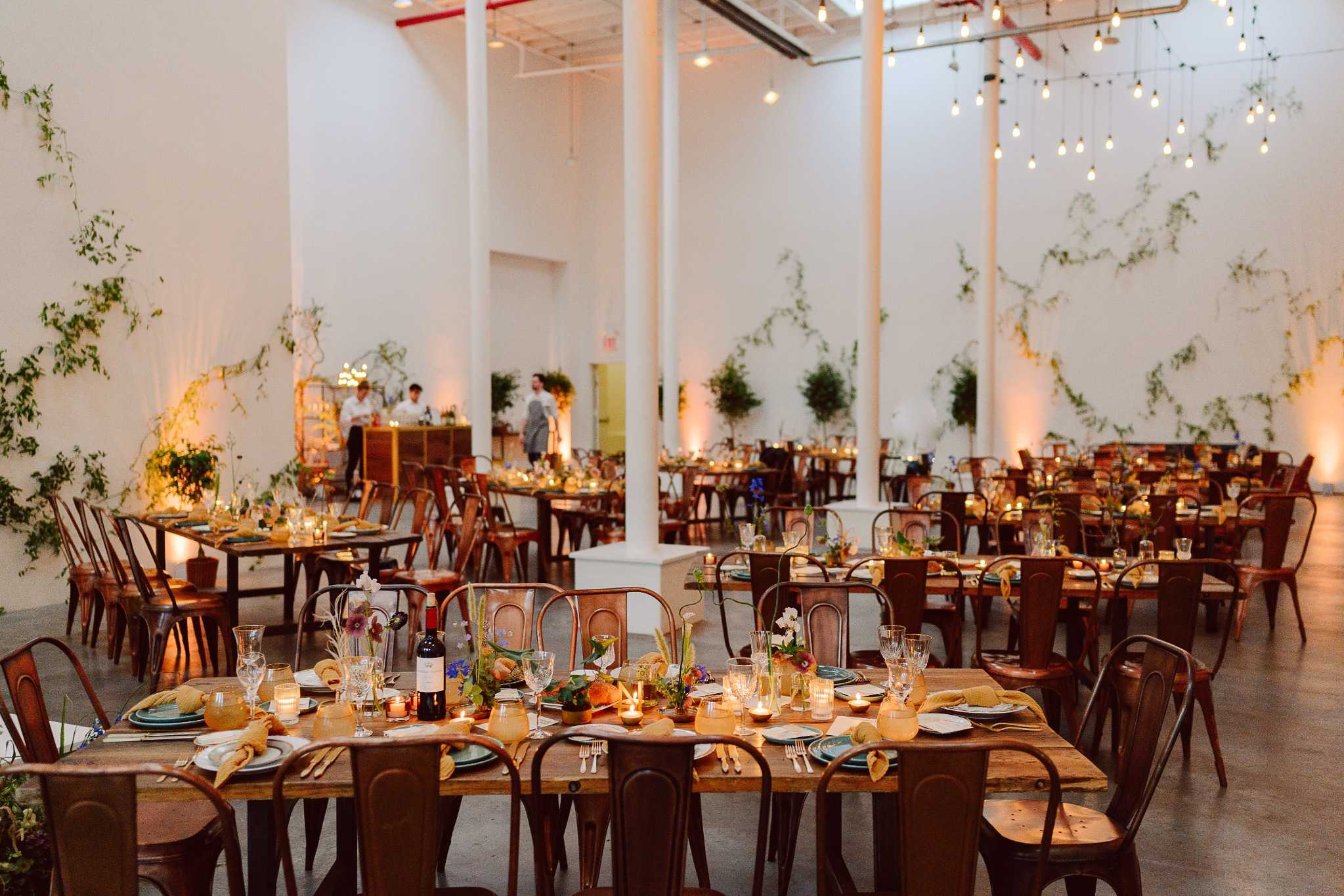 Elegant indoor wedding reception with long tables and greenery Fort Worth