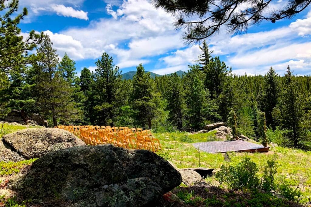 Outdoor wedding ceremony in hills of Idaho surrounded by pine trees