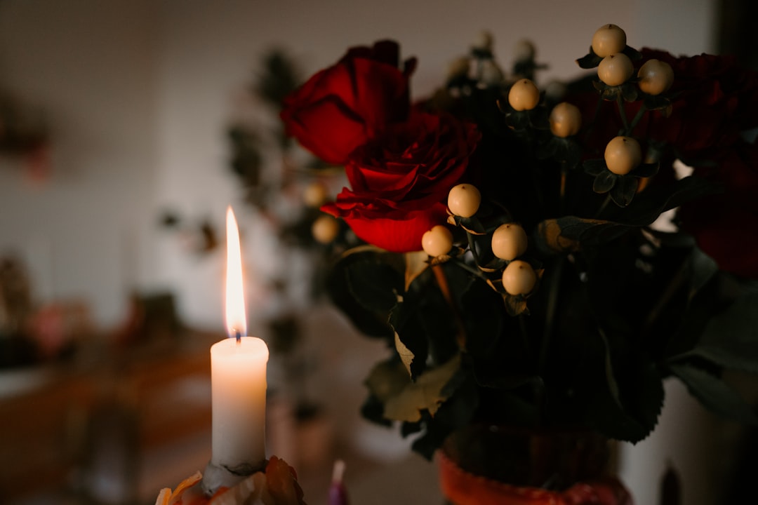 A beautifully arranged table setting featuring candles, fresh flowers, and soft lighting, creating a warm and inviting atmosphere for an occasion.