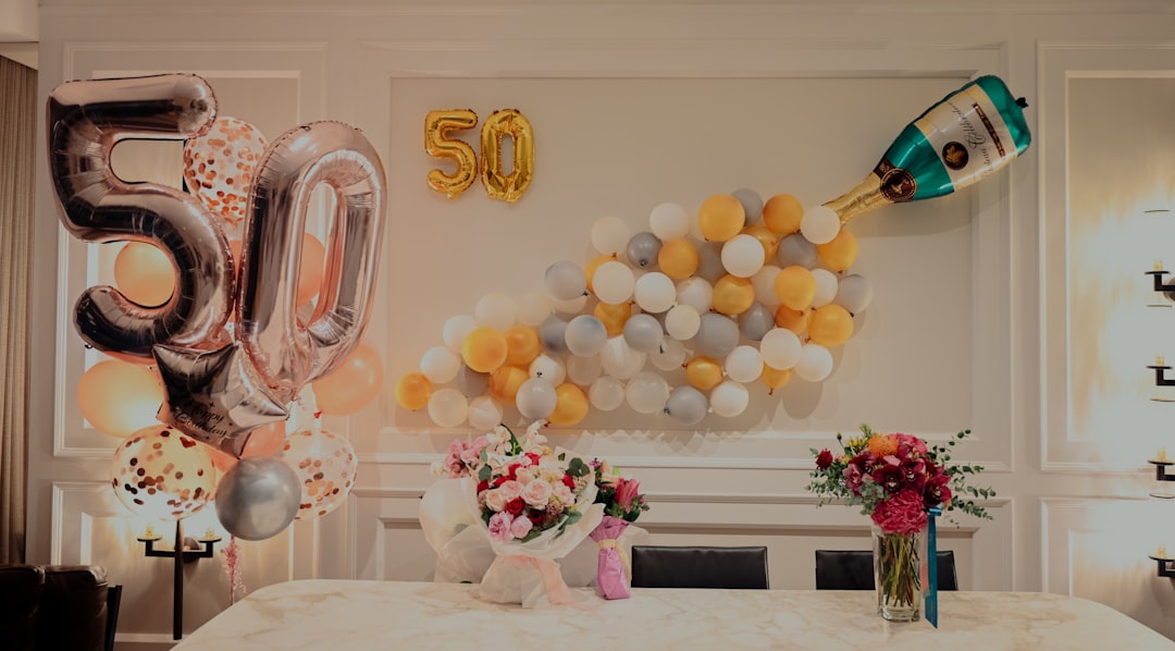 A beautifully arranged party table with coordinated decorations, including matching tableware, centerpieces, and colorful balloons.