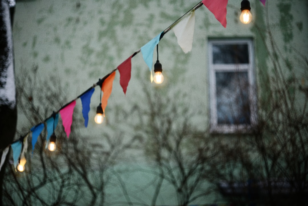 A beautifully decorated outdoor space for an event, featuring simple yet elegant decorations like string lights, table settings, and greenery.